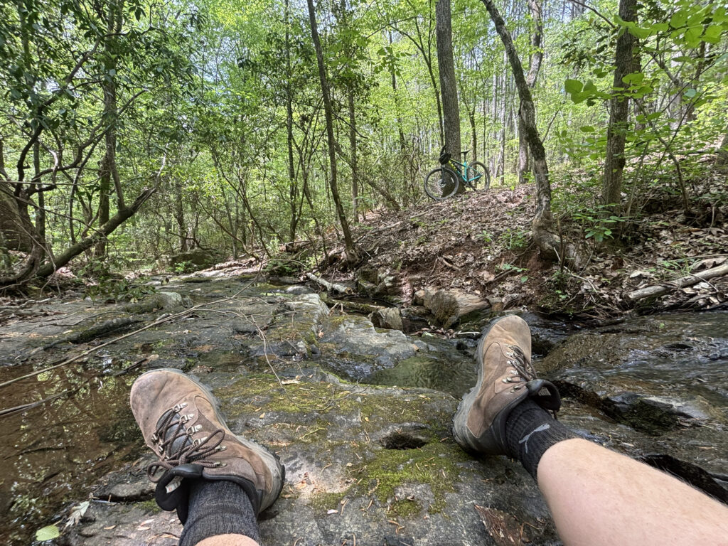 Man sitting on rock after mountain biking at Mountain Creek Park in Sherrills Ford North Carolina