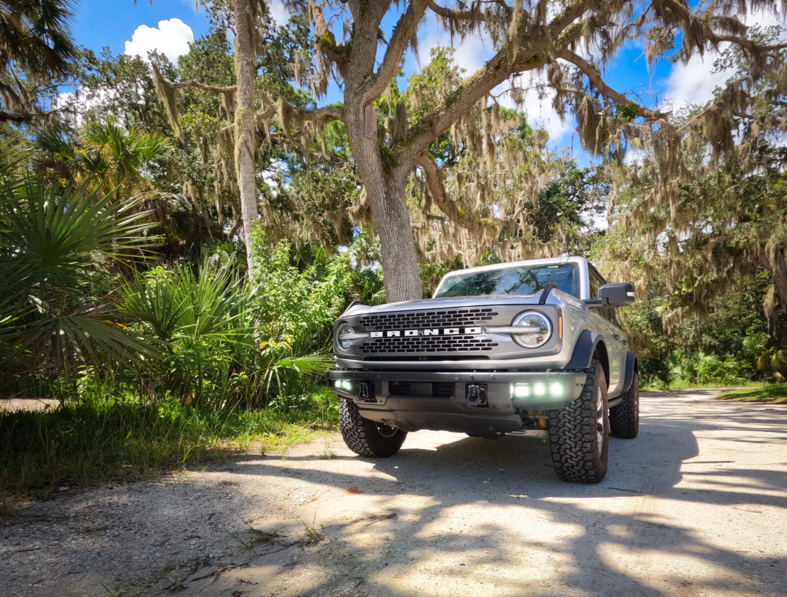 A Ford Bronco Badlands on an off-road trail with off-road fog lights enabled.